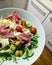 Bowl with lettuce, lamb`s lettuce, tomatoes, fresh white cheese, ham, cabbage, green olives, colorful vegetables, bowl full of vi