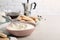 Bowl with mascarpone cream on white wooden table, space for text. Making tiramisu cake