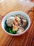 a bowl of meatballs served on a wooden table