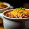 Bowl of Mexican food chili with cheese, selective focus