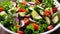 A bowl of mixed vegetables including broccoli, tomatoes, cucumbers, and onions