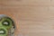 Bowl of muesli with fresh fruits. From above view of white ceramic bowl of muesli with slices of fresh kiwi fruit on wooden table