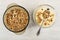 Bowl with muesli, spoon with granola in bowl with fruit yogurt on wooden table. Top view