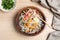 Bowl of noodles with broth, vegetables and egg on wooden background