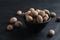 Bowl with nutmeg seeds on black table, closeup