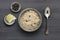 A bowl of nutritious blueberry and apple porridge and a small bowl of  apple and blueberries, with a spoon, on a dark wooden