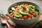 Bowl of nutritious vegan food avocado quinoa tomato cucumber veggie salad.