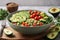 Bowl of nutritious vegan food avocado quinoa tomato cucumber veggie salad.