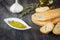 Bowl with olive oil dip, bread, garlic, rosemary and olive oil in glass bottle. Greek bread dipping.