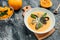 Bowl of orange pumpkin puree soup with pumpkin seeds, seafood, mussels, shrimps, blue cheese, mold served in bowl, top view