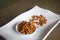 Bowl of organic peanuts on ceramic white plate