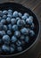 A bowl of picked black grapes