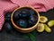 Bowl with plums with green leaves