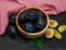 Bowl with plums with green leaves