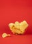 Bowl of potato chips in bright red background. Minimalistic image of attention grabbing fast food in vivid colors