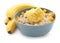 Bowl with prepared oatmeal, dried pineapple and bananas on white background