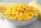 Bowl of preserved corn on white table, closeup