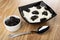 Bowl with prune, cottage cheese with sour cream and prunes in bowl, spoon on wooden table