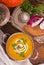 Bowl of pumpkin soup on rustic wooden background