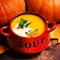 Bowl of pumpkin soup swirled with coconut cream with fresh pumpk