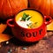 Bowl of pumpkin soup swirled with coconut cream with fresh pumpk