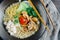 A bowl of ramen with mushrooms, tomatoes, and green vegetables