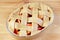 Bowl of raw apple pie with decorative woven lattice top crust ready for baking