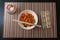 Bowl with Rice, Vegetables and Chopsticks on a Bamboo Placemat