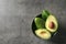 Bowl with ripe avocados on dark grey background