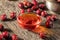 A bowl of rosehip seed oil with dried rosehips