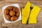 Bowl with round fried pies, fork on paper napkins on wooden table. Top view