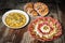 Bowl Of Russian Salad With Appetizer Savory Dish Meze And Pretzel With Sesame Croissant Snail Roll Set On Old Garden Table