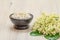 Bowl with sea salt and bouquet of lilies of the valley on wooden background