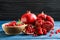 Bowl with seeds and ripe pomegranates on table