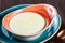 Bowl of semolina porridge with butter on dark wooden background close up.