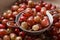 Bowl with sieve full of ripe gooseberries, closeup