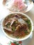 A Bowl of Soto Padang with Rice and Crackers