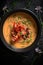 A bowl of soup with lobster and garnish. Generative AI image.