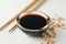 Bowl of soy sauce, soy beans on background, space for text. Closeup