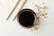 Bowl of soy sauce, soy beans on background, space for text. Top view