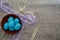 Bowl of speckled blue eggs with pastel ribbon on a rustic table