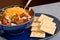 Bowl of spicey chili and crackers with a spoon