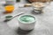 Bowl of spirulina facial mask on grey