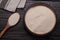 Bowl and spoon with active dry yeast on wooden table, flat lay