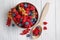 Bowl and spoon with different ripe berries on wooden table