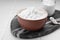 Bowl, spoon and glass jar of natural starch on white tiled table