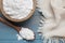 Bowl and spoon of natural starch on light blue wooden table, flat lay