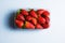 Bowl of strawberries on blue background