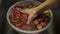 Bowl with strawberries soaked in water to clean the fruit of dirt with a womans hand.