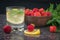 A bowl of strawberries, water with lemon and mint on a stone table.